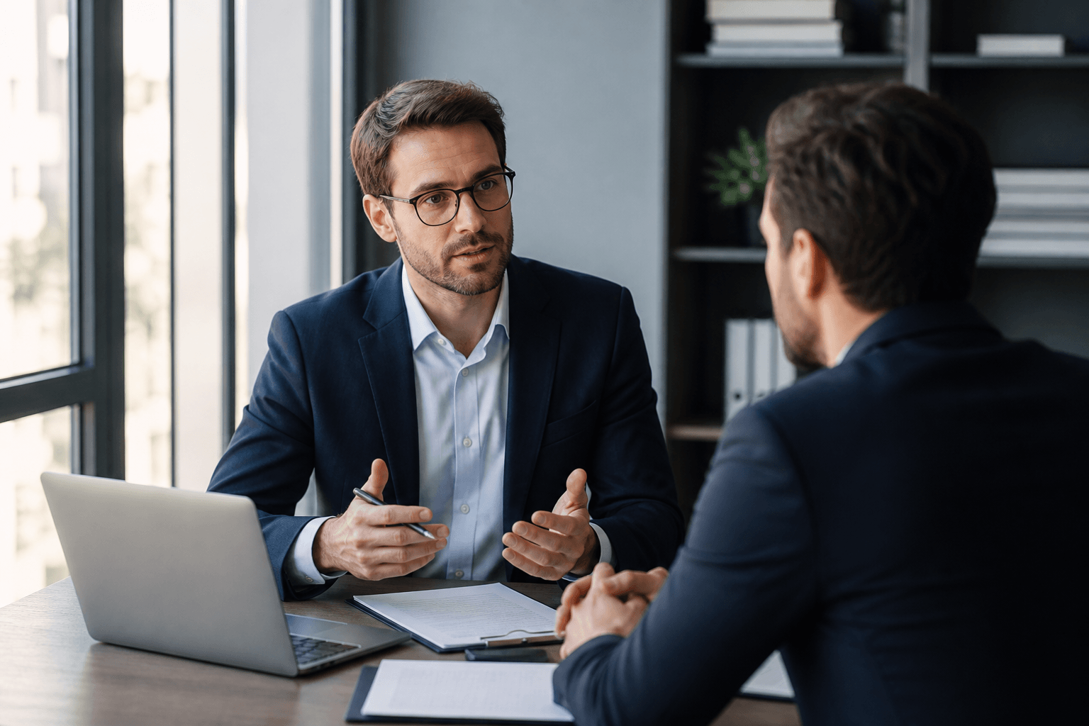 Financial advisor meeting a client across a desk in a modern office