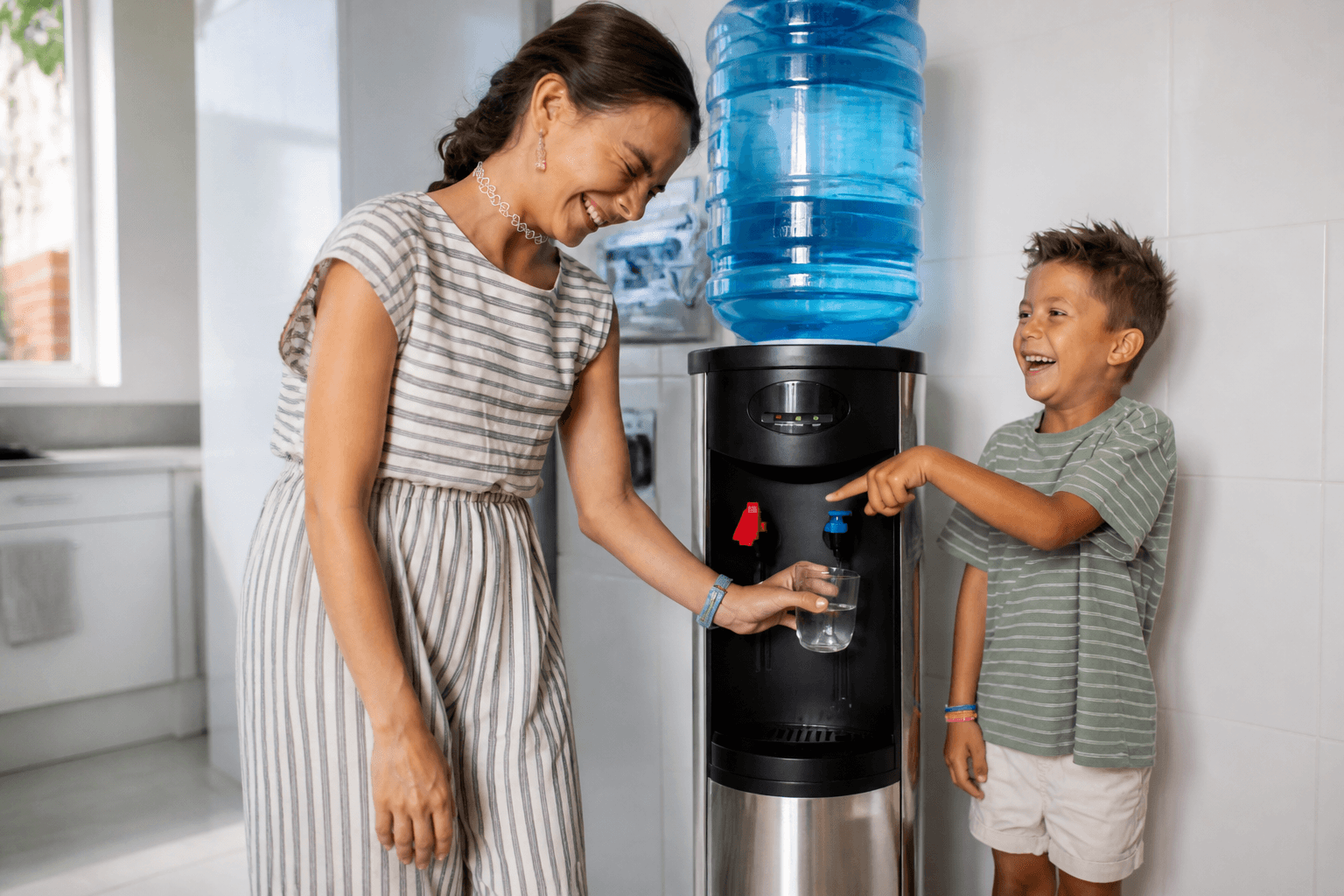 Madre e hijo sonriendo mientras llenan un vaso en un dispensador de agua